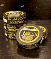 Stacked cans of Jake's Mint Chew Bold Brew pouches with a close-up of one can in the foreground, promoting a tobacco-free and nicotine-free coffee-flavored alternative