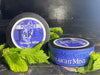 Two cans of Jake's Mint Chew Straight Mint pouches placed with fresh mint leaves, promoting a tobacco-free and nicotine-free mint-flavored alternative